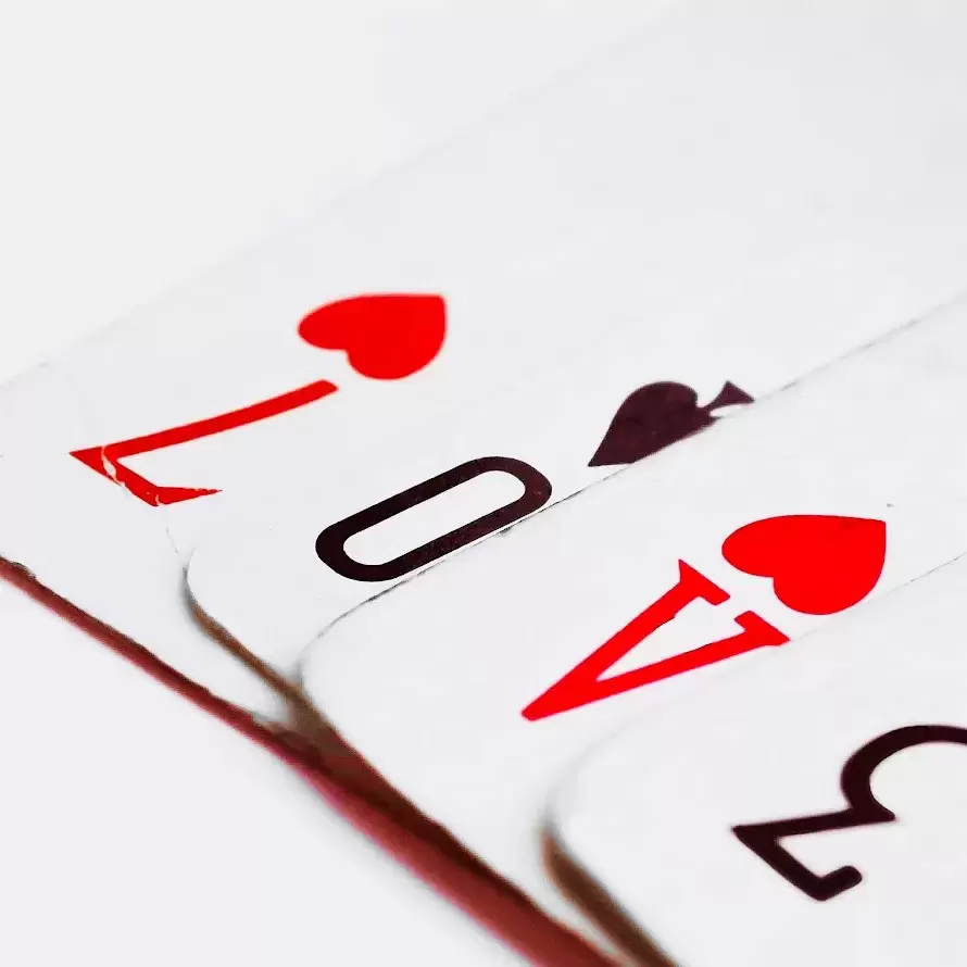 closeup of playing cards covering each other so the numbers look like they spell out 