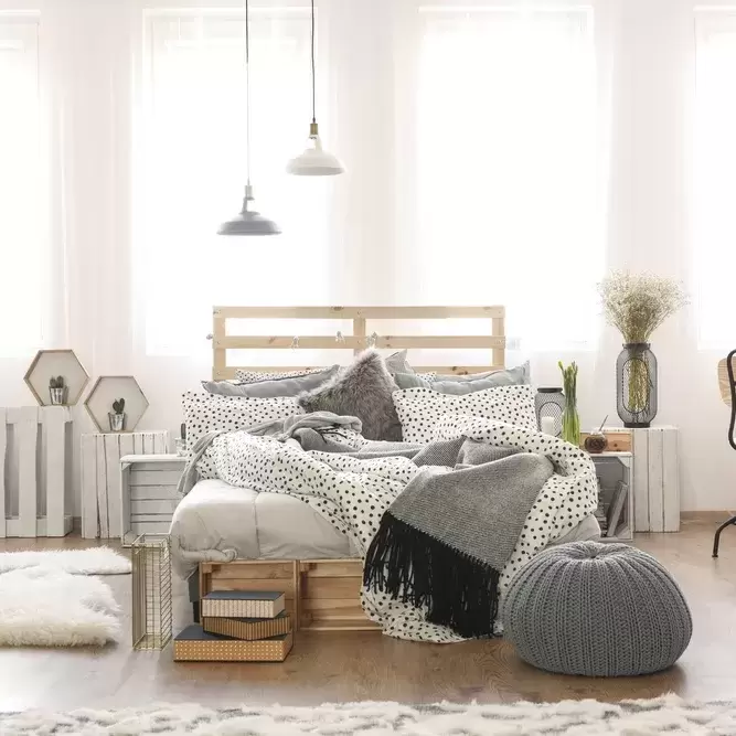 a clean bedroom with a white and gray bedspread